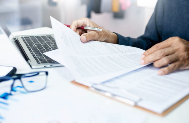 A professional looking over insurance documents on a modern desk